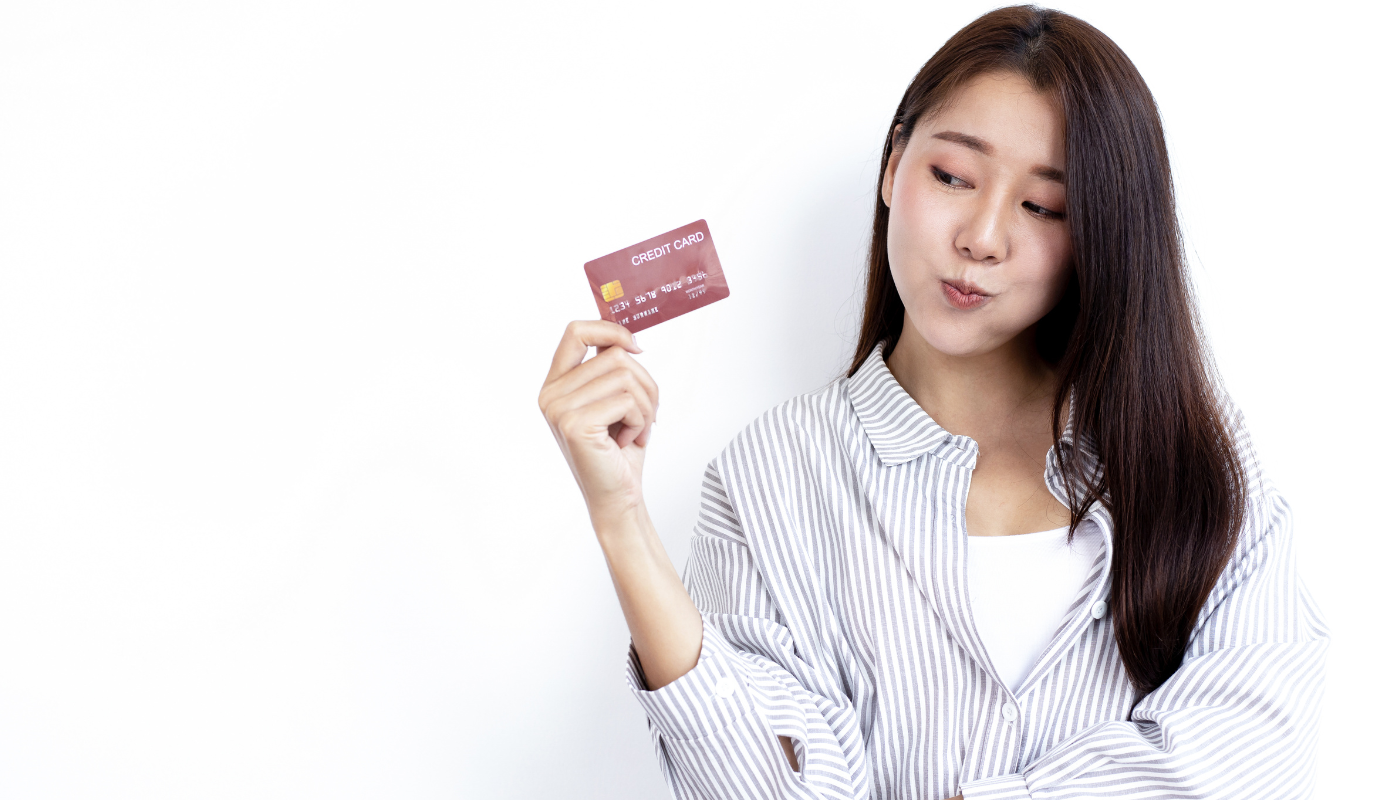 Mujer joven sosteniendo una tarjeta de crédito